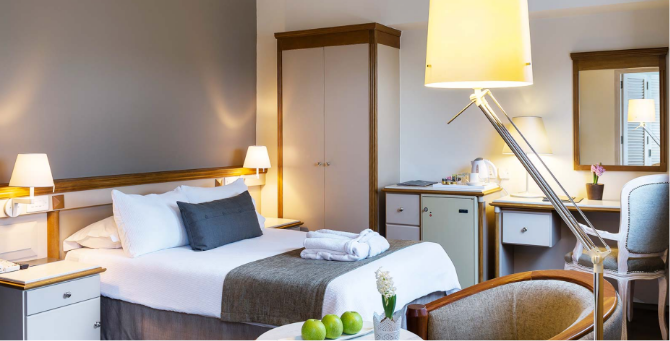 Alasia hotel bedroom including, bed, wardrobe, nightstand and night lamps.